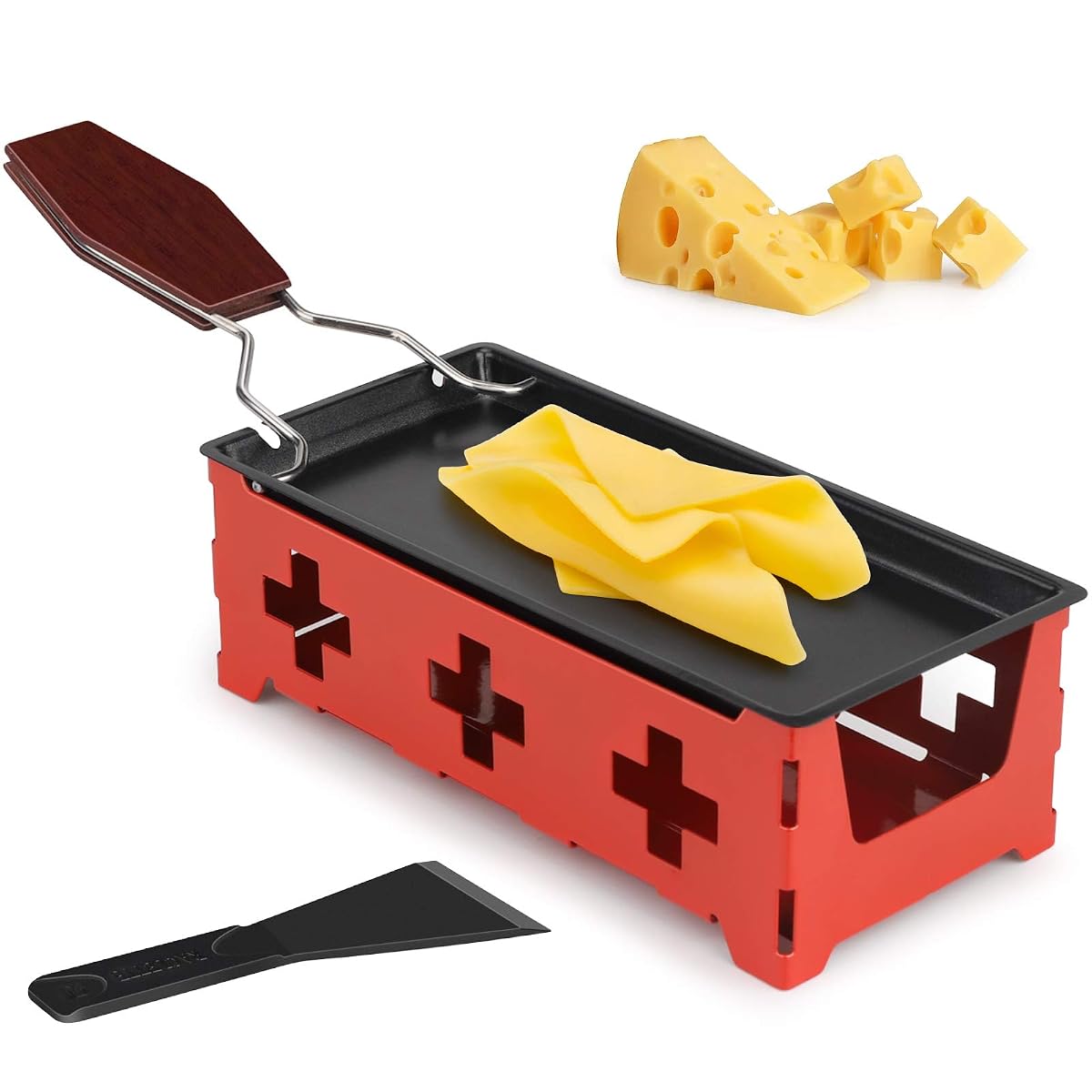 Mini raclette à bougies avec poêle antiadhésive, cadre rouge et spatule en silicone sur une table en bois.