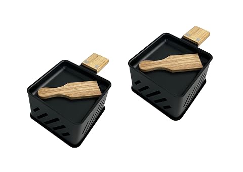 Deux poêlons noirs en fer et deux spatules en pin posés sur une table en bois clair