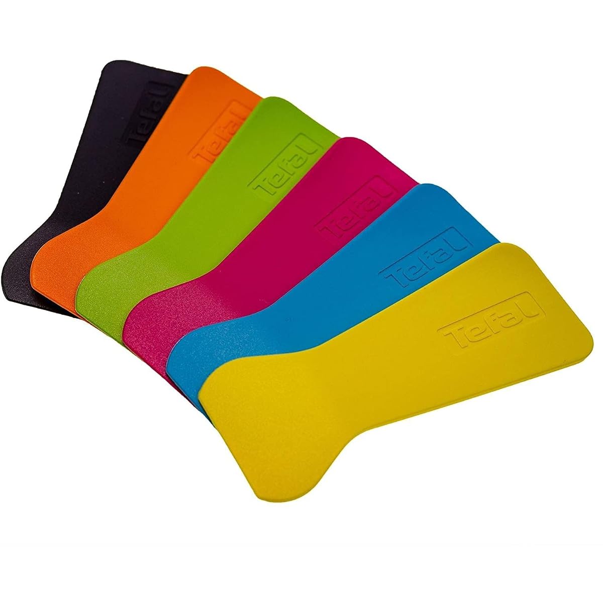 Six spatules thermoplastiques multicolores et six œilletons posés près d’un appareil à raclette