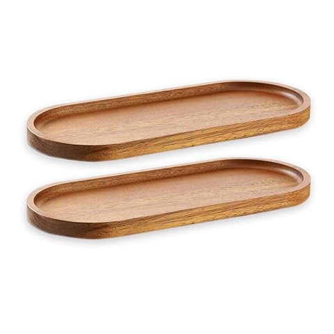 Deux plateaux étroits en bois d’acacia garnis de fromage, charcuterie et olives sur une table claire.