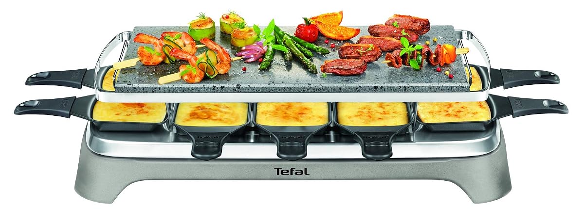 Appareil à raclette en inox avec pierre de lave, coupelles et grattoirs sur une table en bois clair