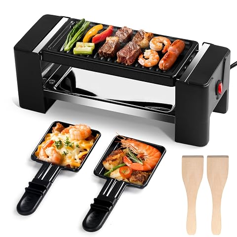 Mini appareil à raclette noir avec plaque grill, deux poêlons et spatules en bois sur une table claire.