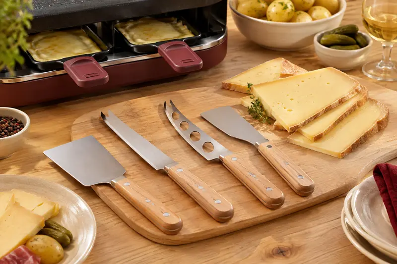 Couteaux à fromage disposés sur une planche près de tranches de fromage